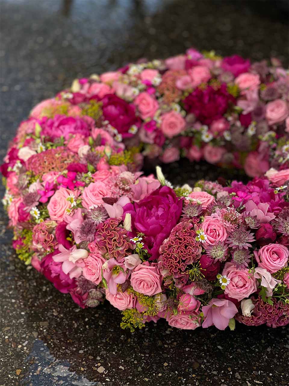 Ein Blumenkranz in kräftigem Rosa für eine Trauerfeier