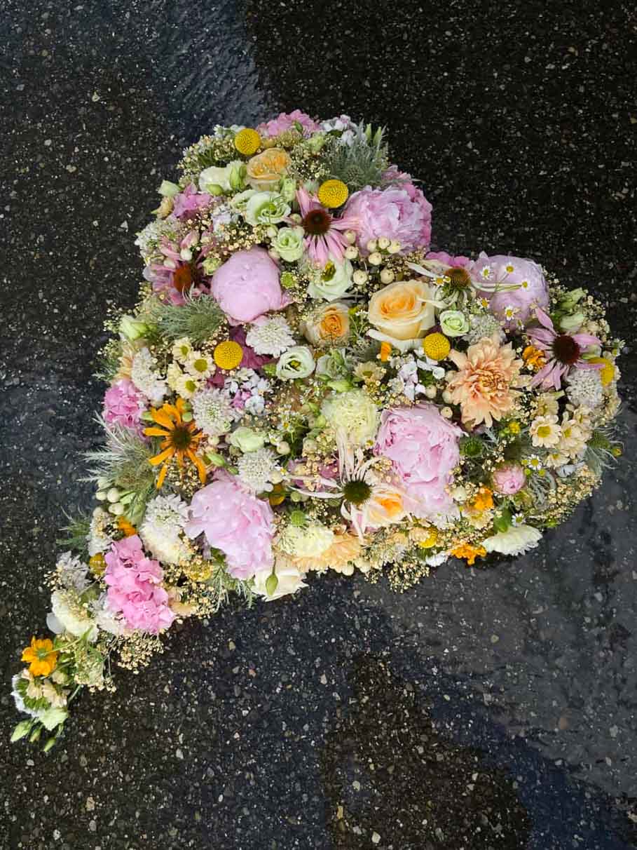 Blumenkranz in Herzform in Pink und Gelb für eine Trauerfeier