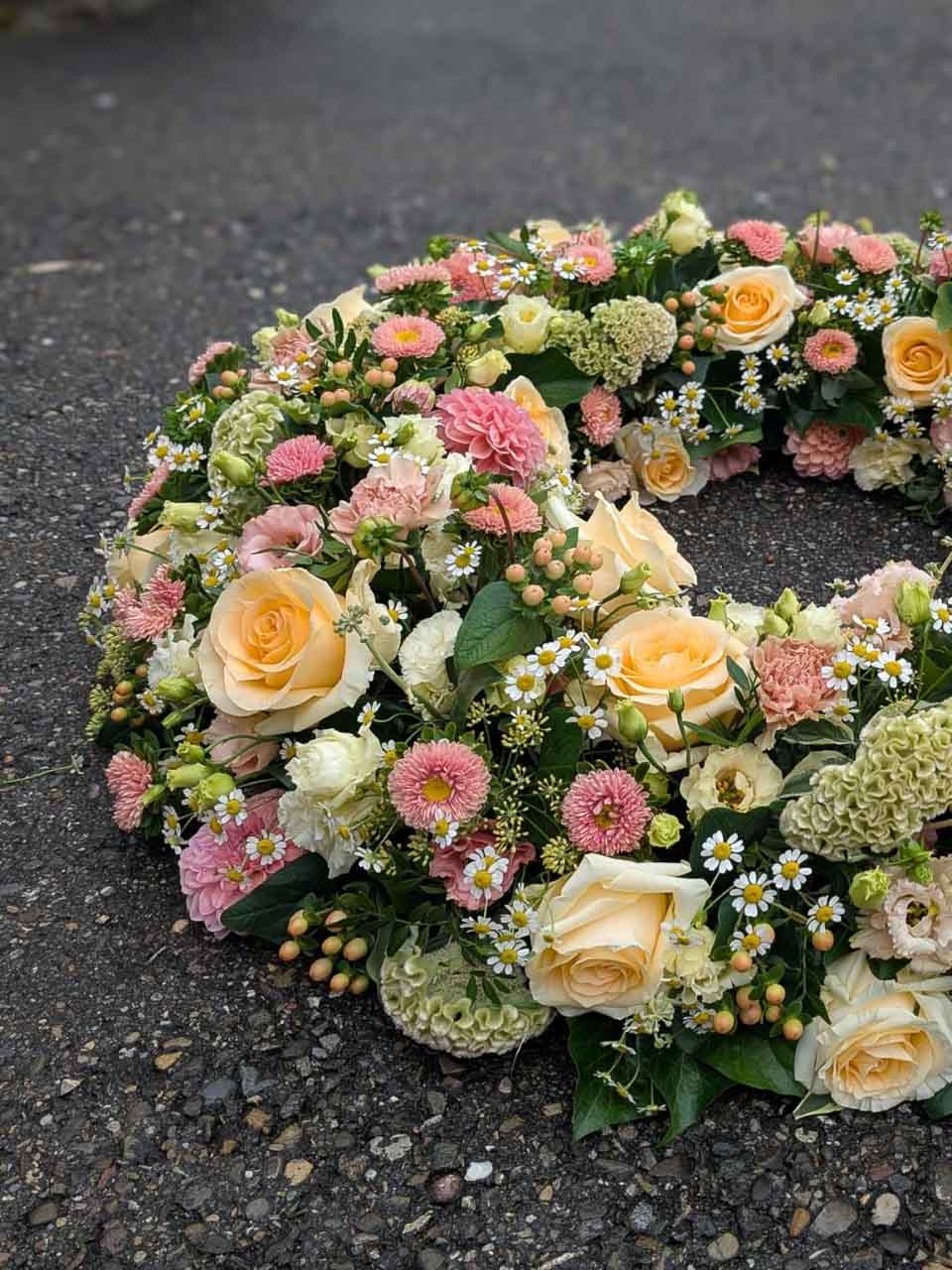 Blumenkranz in Hellrosa und Gelb für eine Trauerfeier